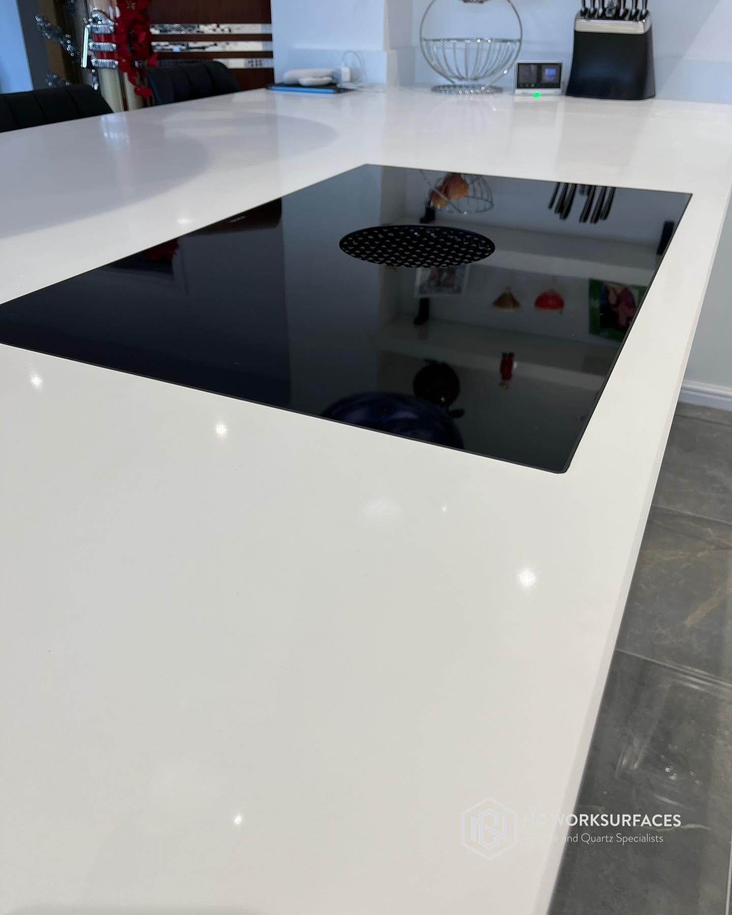 Flush-fitting hob cut into a stone worktop by NC Worksurfaces